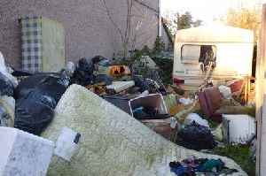 'Eyesore' piles of rubbish and old caravan finally removed from Swansea garden