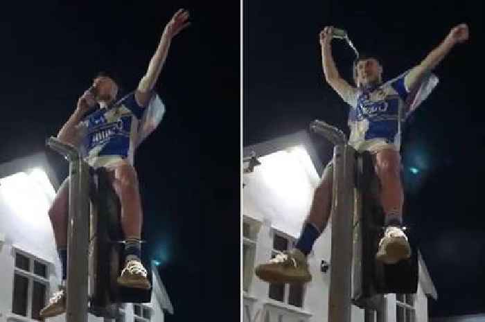 Footballer drenches himself with beer on top of traffic lights after dramatic promotion
