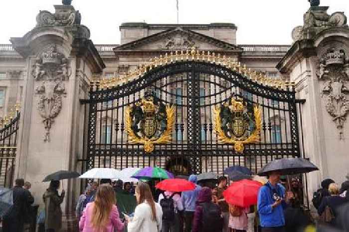 People lay flowers outside Buckingham Palace as crowds gather