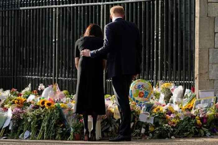 Meghan Markle and Prince Harry comfort each other as they look at Queen tributes