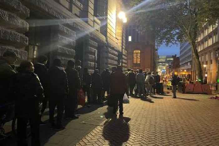 Hungry people queue for food in a side street close to the Conservative Party conference