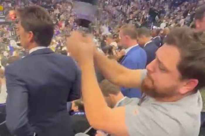 Hyped Sacramento Kings fan shakes cowbell behind Golden State Warriors general manager