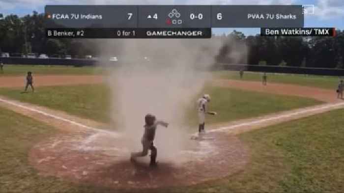 Umpire saves young boy on field as dust devil engulfs him