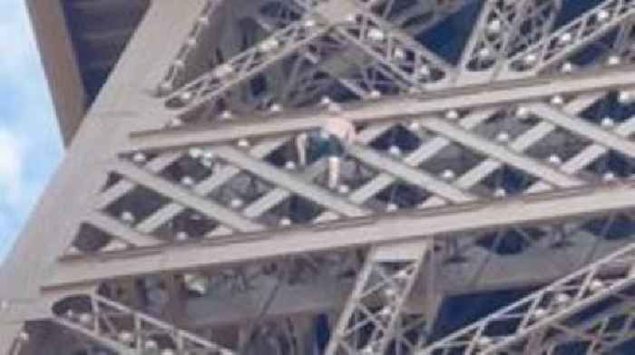 Man seen climbing Eiffel Tower above Olympic rings