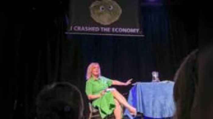 Liz Truss leaves stage as lettuce banner unfurls