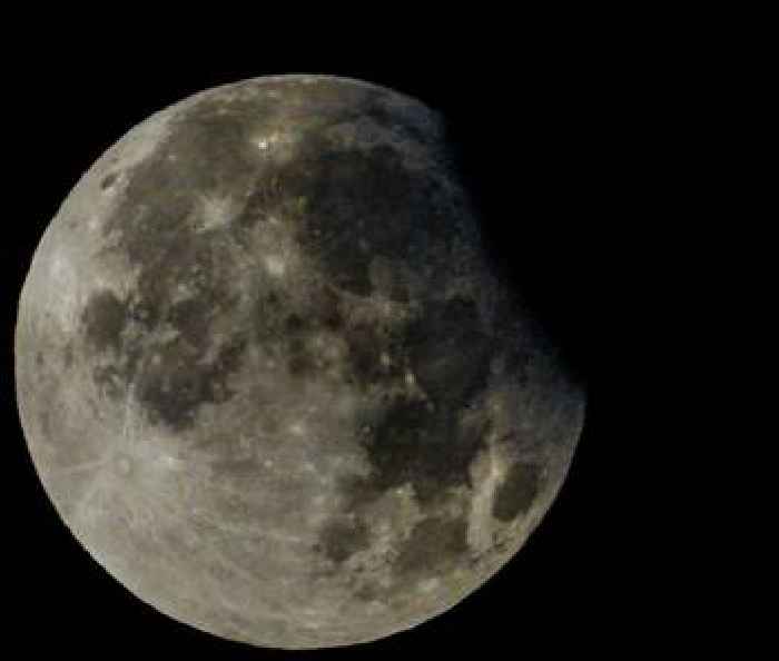 Rare partial eclipse of harvest supermoon delights UK stargazers