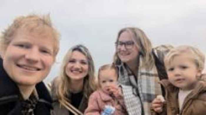 Ed Sheeran poses with fans during beach filming