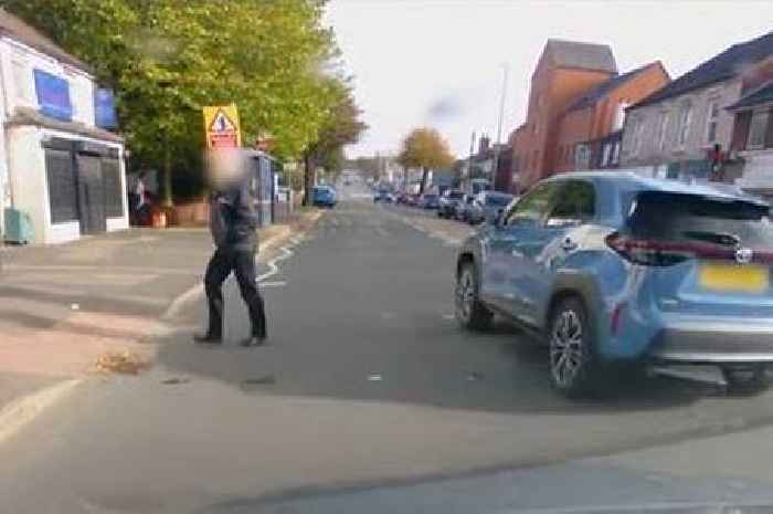 Moment dangerous driver runs red light at crossing narrowly avoiding pedestrian