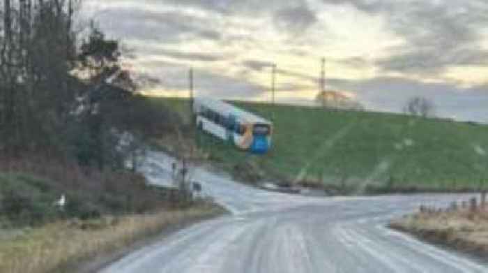 Icy road warning after bus gets stuck in field