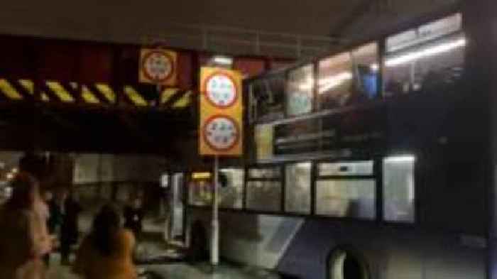 Double decker bus wedged under bridge after crash