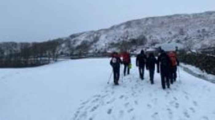 Walkers 'waist-deep in snow' rescued from mountain