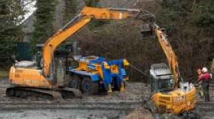 Watch: Stranded digger rescued from drained pond