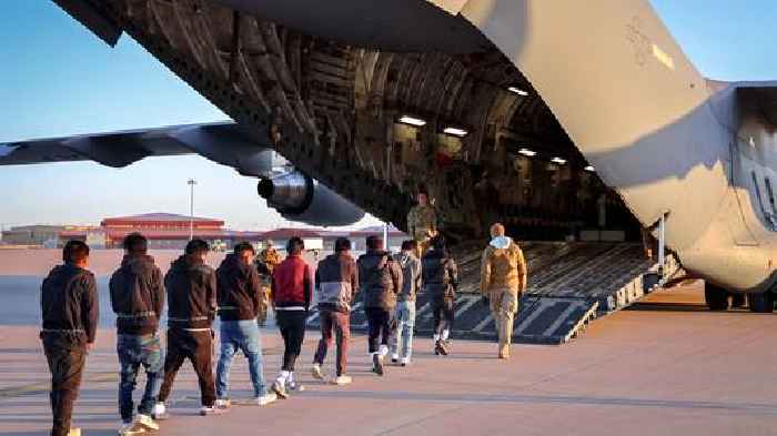 Men in shackles led on to US military plane as immigration arrests on rise