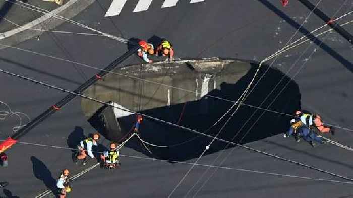 Swimming pool-sized sinkhole swallows truck on busy road, trapping driver