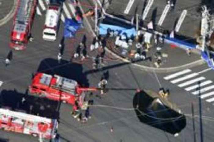 Sinkhole in Japan widens as rescuers try to save truck driver