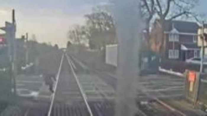 Woman's near miss with train at level crossing