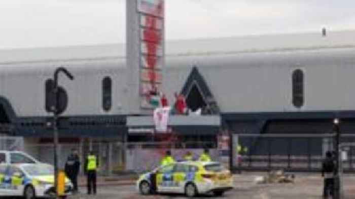 Protesters climb on top of arms factory gatehouse