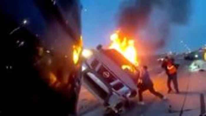 Watch as first responders rescue woman from burning car