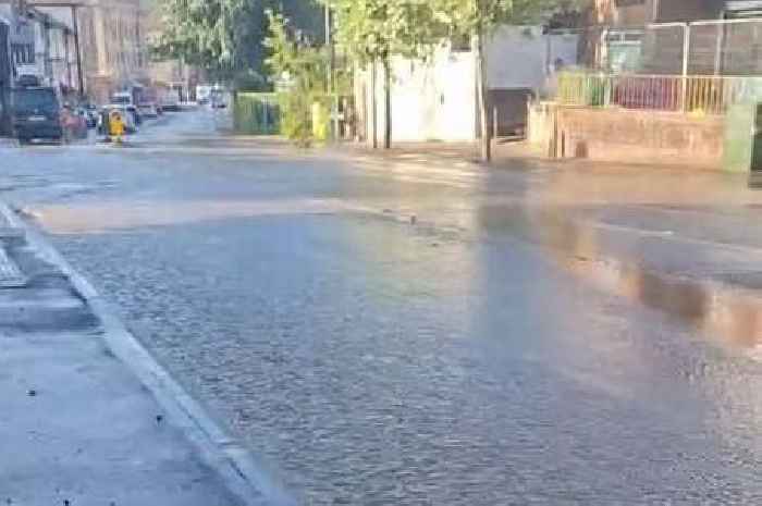 Water cascades down city street as pipe bursts