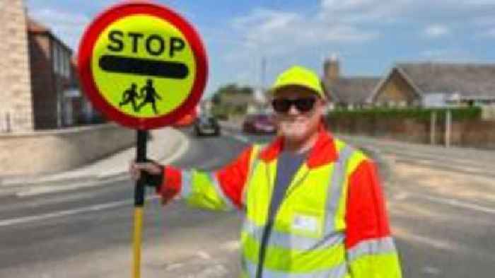 Lollipop man told to stop giving kids high-fives