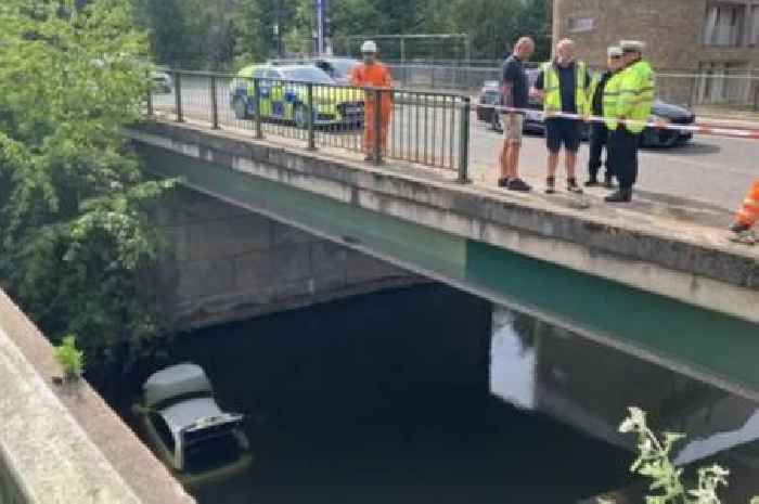 Car lands in canal after van crash as woman rushed to hospital