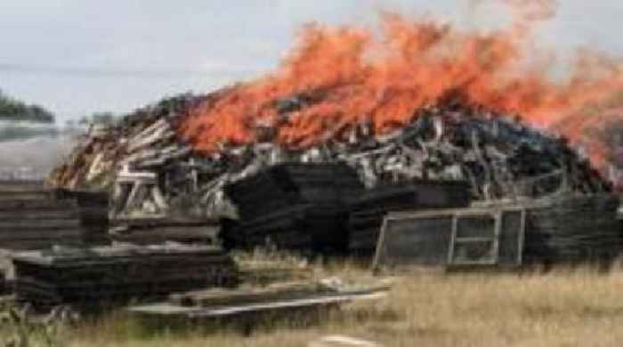 Large fire in wood pile 'challenging' for crews