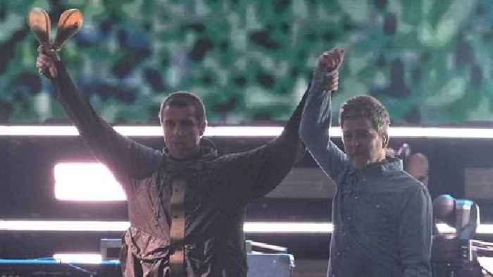 Gallagher brothers share a high-five and hug as Oasis reunite on stage after 16 years