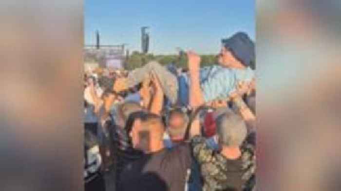 Disabled Oasis fan lifted above the crowds at gig