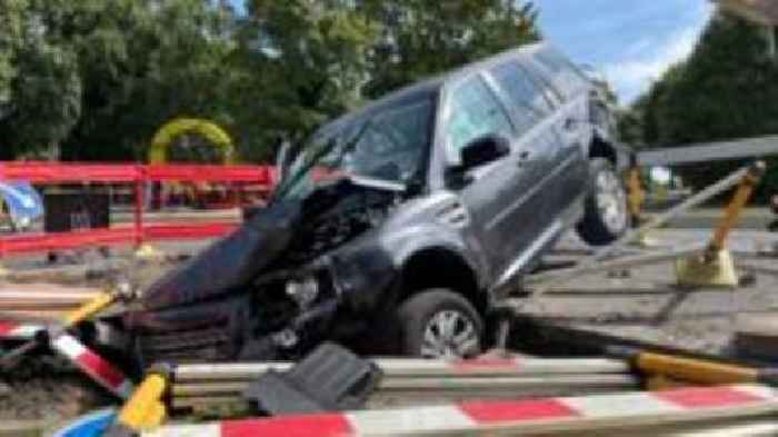 Two hurt after car crashes into gas mains trench