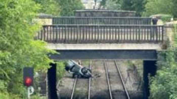 Trains cancelled after car crashes onto tracks