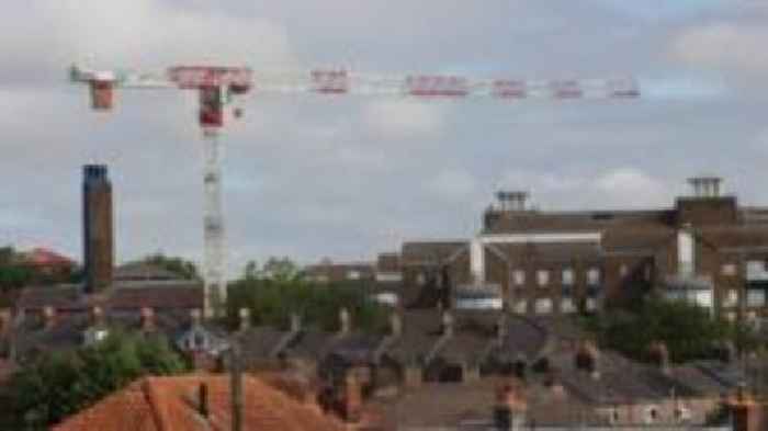 Hospital construction crane in place above market town