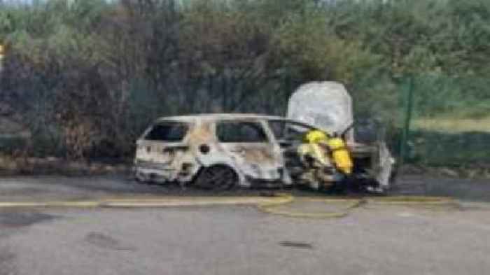 Road partially shut as car fire spreads to heath
