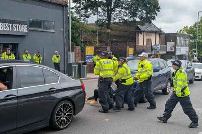 Woman draped in England flag in scuffle with police at Hanley asylum seeker hotel protest